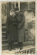 Po 1939, brak miejsca.
Dziewczyna w stroju zimowym i chłopak w płaszczu zimowym Armii Czerwonej przed domem.
Fot. NN, zbiory Archiwum Historii Mówionej Ośrodka KARTA i Domu Spotkań z Historią, udostępniła Janina Leszczyńska w ramach projektu 