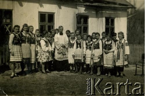 Przed 1939, brak miejsca.
Zdjęcie grupowe dziewcząt w strojach ludowych z księdzem. Fotografia z rodzinnego archiwum Zofii Hurko.
Fot. NN, zbiory Archiwum Historii Mówionej Ośrodka KARTA i Domu Spotkań z Historią, udostępniła Zofia Hurko w ramach projektu 