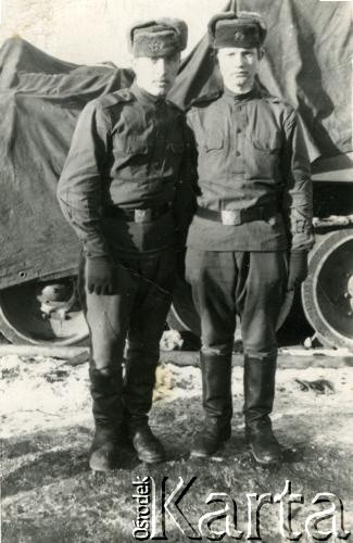 Po 1945, ZSRR.
Dwaj mężczyźni w mundurach polowych Armii Czerwonej. W tle pojazd gąsienicowy ukryty pod plandeką.
Fot. NN, zbiory Archiwum Historii Mówionej Ośrodka KARTA i Domu Spotkań z Historią, udostępnił Wasyl Dworecki w ramach projektu 