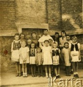 Przed 1939, Czortków, Polska.
Zdjęcie grupowe, dzieci, kobiety i mnich w białym habicie - dominikanin. Dzieci w strojach ludowych. Kościół dominikanów pod wezwaniem św. Stanisława.
Fot. NN, zbiory Archiwum Historii Mówionej Ośrodka KARTA i Domu Spotkań z Historią, udostępniła Anna Wołkowa w ramach projektu 