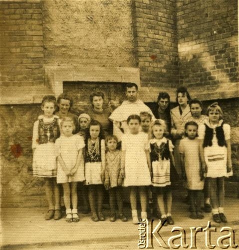 Przed 1939, Czortków, Polska.
Zdjęcie grupowe, dzieci, kobiety i mnich w białym habicie - dominikanin. Dzieci w strojach ludowych. Kościół dominikanów pod wezwaniem św. Stanisława.
Fot. NN, zbiory Archiwum Historii Mówionej Ośrodka KARTA i Domu Spotkań z Historią, udostępniła Anna Wołkowa w ramach projektu 