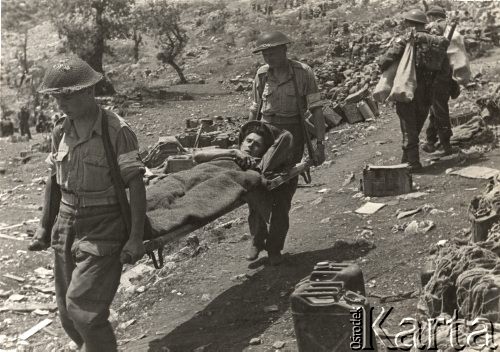 18.05.1944, Monte Cassino, Włochy.
Bitwa pod Monte Cassino – sanitariusze niosący na noszach rannego żołnierza. 
Fot. Władysław Choma, zbiory Instytutu Józefa Piłsudskiego w Londynie (pieczątka: 3 Dywizja Strzelców Karpackich Referat Kultury i Prasy).
