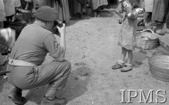 Maj 1944, Monte Cassino, Włochy
Na ulicy miasteczka - fotograf robiący zdjecie dziewczynce w brudnej sukience.
Fot. por. Ostrowski, Instytut Polski im. Gen. Sikorskiego w Londynie [album negatywowy L-II Monte Cassino] - płachta 6