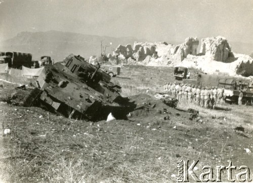 1944, wzgórze Monte Cassino, Włochy.
Krajobraz po bitwie. Służby Czerwonego Krzyża podczas penetracji wzgórza. Z lewej strony, u góry widoczne dwa rozstawione namioty, z prawej strony pułk  żołnierzy podczas zbiórki. Na pierwszym planie tył zniszczonego dziala szturmowego. W tle zrujnowane wzgórze klasztorne w rejonie Monte Cassino. 
Fot. NN, zbiory Ośrodka KARTA, udostępniła Magdalena Braun