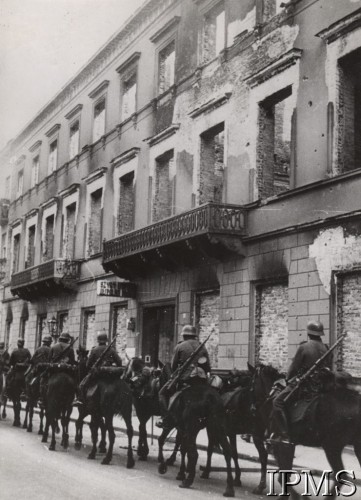 Październik 1939, Warszawa, Polska
Oddział niemieckiej kawalerii wkracza do miasta, z prawej zniszczona kamienica.
Fot. NN, Instytut Polski i Muzeum im. gen. Sikorskiego w Londynie [szuflada nr 51 – Wrzesień 1939]