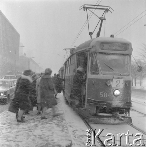 Grudzień 1975, Warszawa, Polska.
Zima w stolicy, przystanek tramwajowy u zbiegu ulic Marszałkowskiej i Świętokrzyskiej, pasażerowie wsiadający do tramwaju nr 2 podczas śnieżycy.
Fot. Romuald Broniarek/KARTA